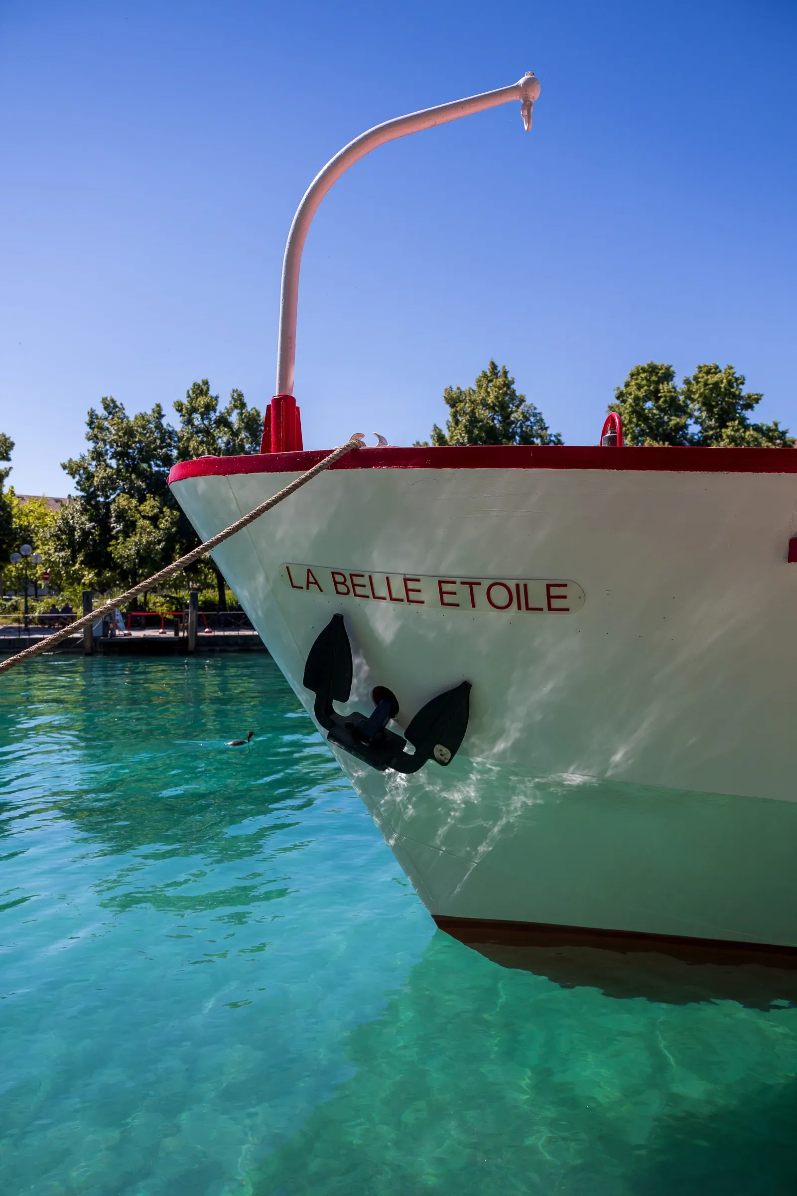 Bow of the boat La Belle Étoile moored on crystal-clear turquoise water, Annecy