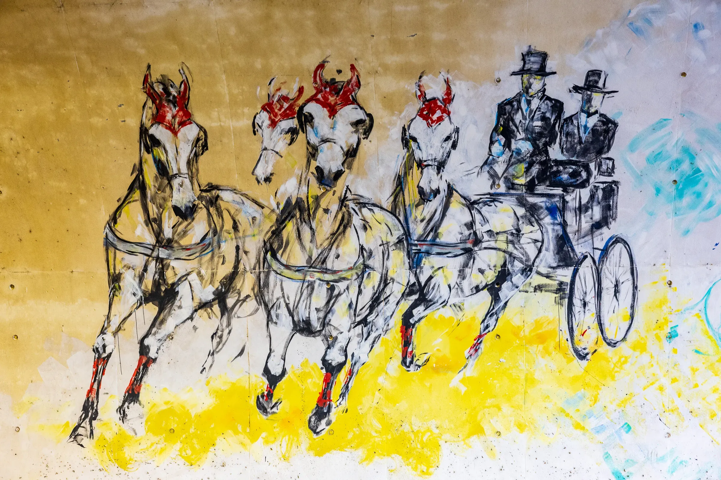 Close-up of tunnel mural — three horses pulling a carriage with two figures in top hats, yellow paint splashes beneath, Saumur