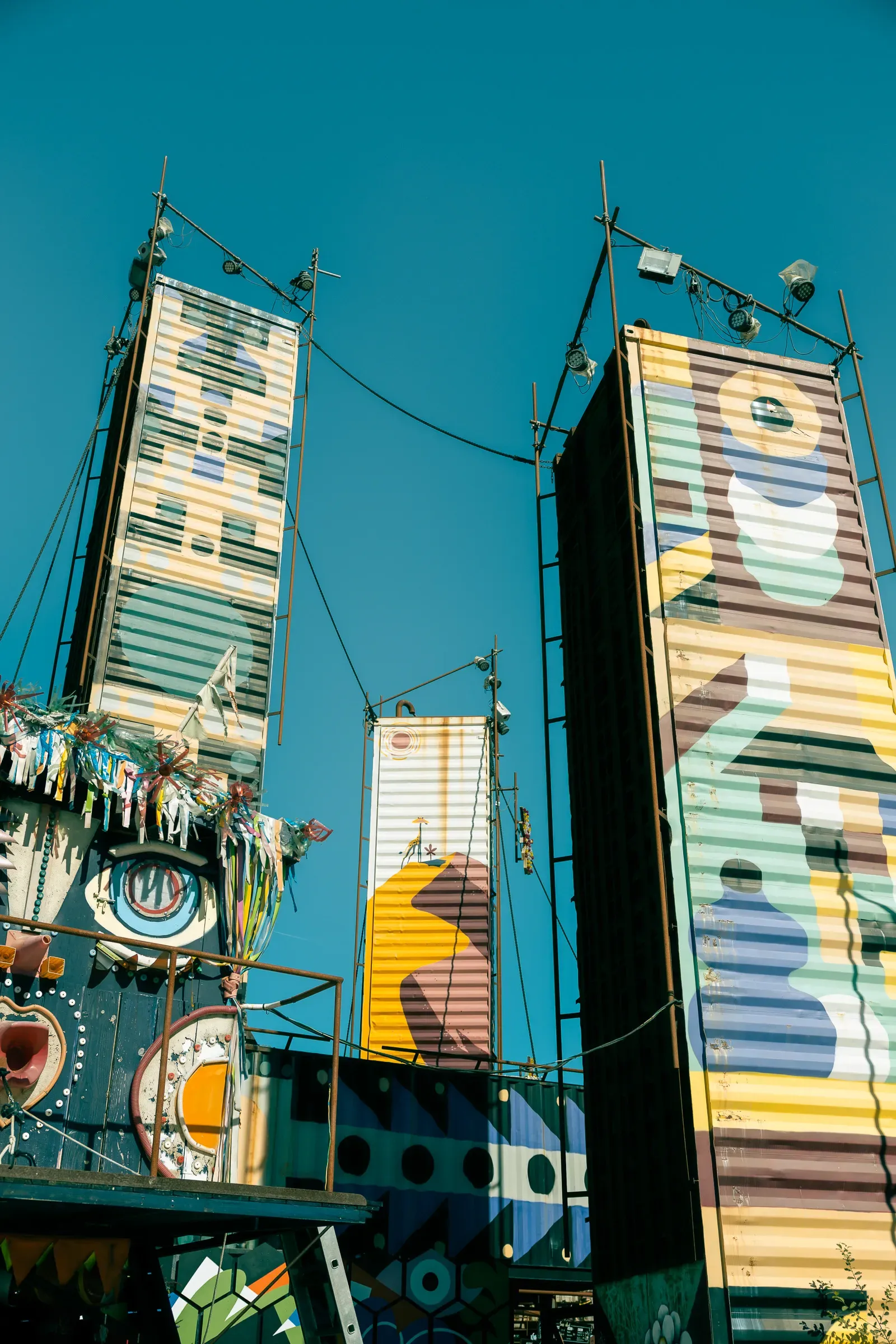 Colorful painted shipping container towers with letters and geometric patterns, Transfer Autolargue, Nantes