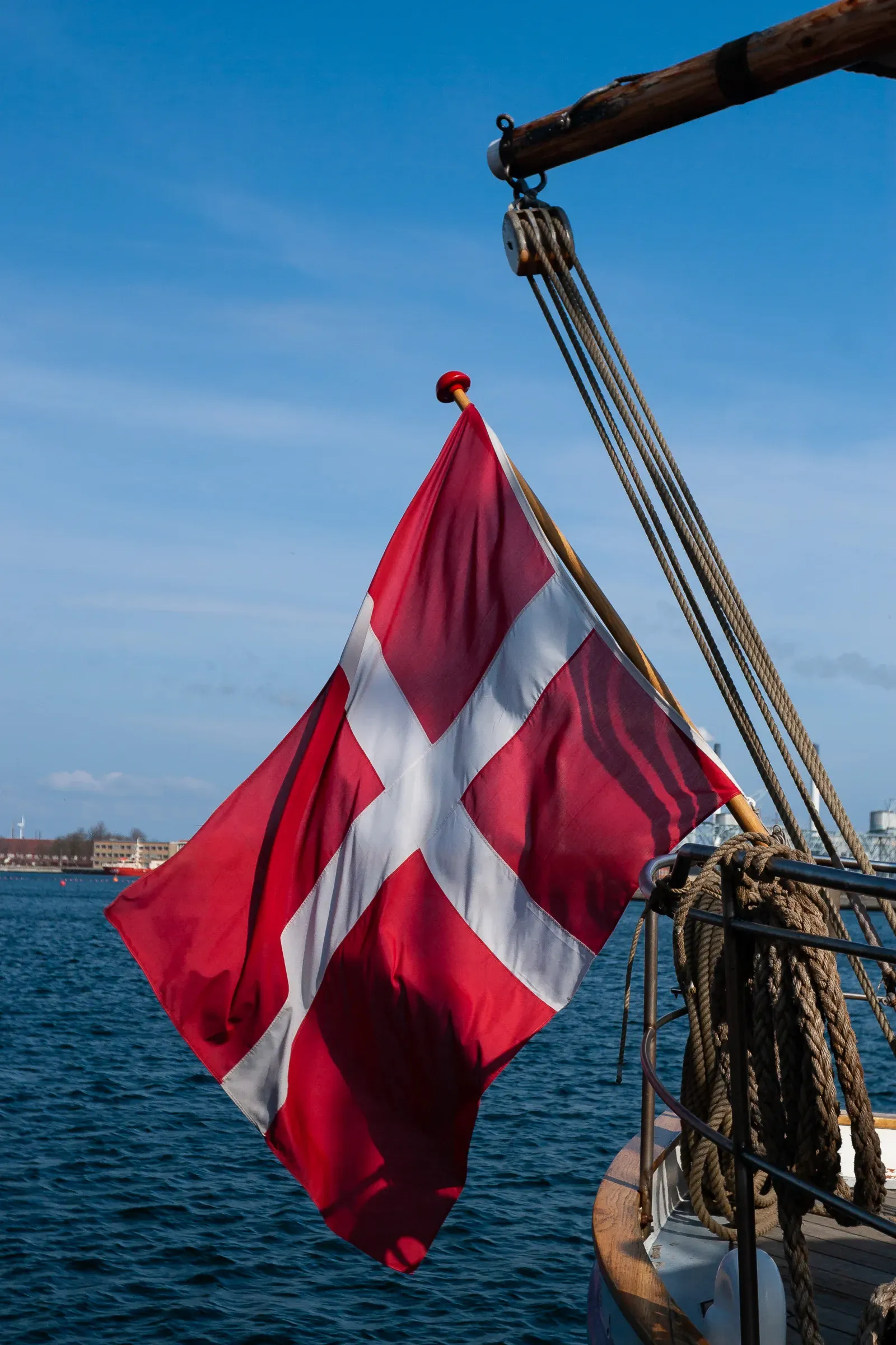 Danish flag flying from the mast of a wooden sailing ship