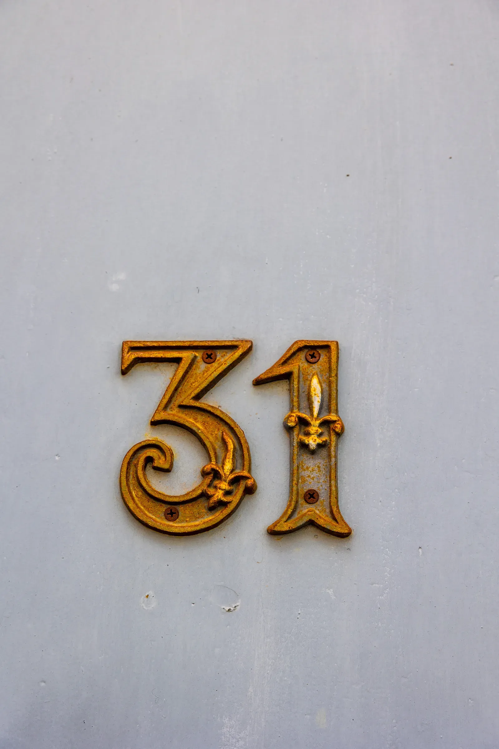 Gold ornate number 31 on a pale grey door, Lille