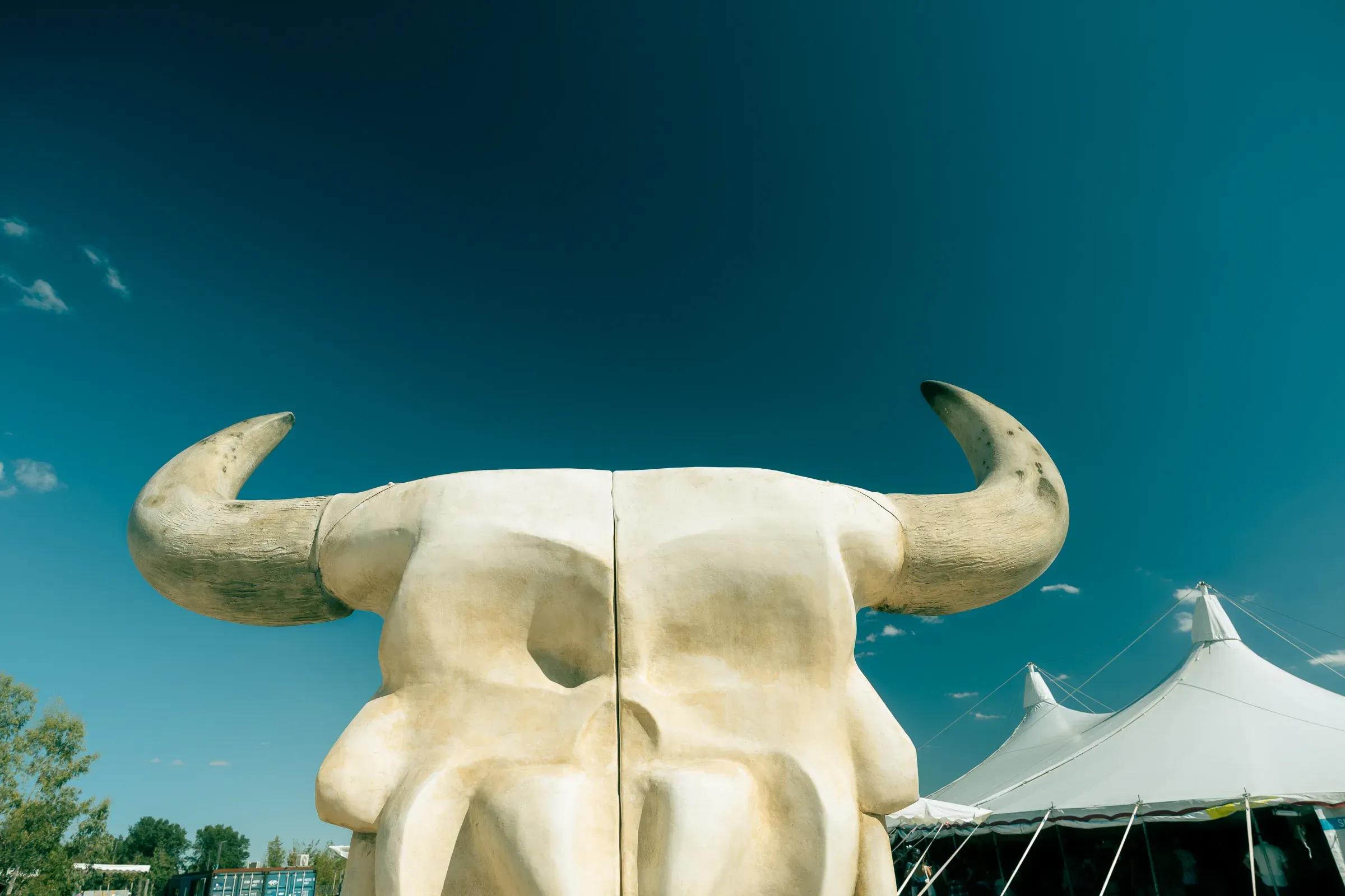 Giant bull skull sculpture against a blue sky at the Transfer Autolargue festival, Nantes